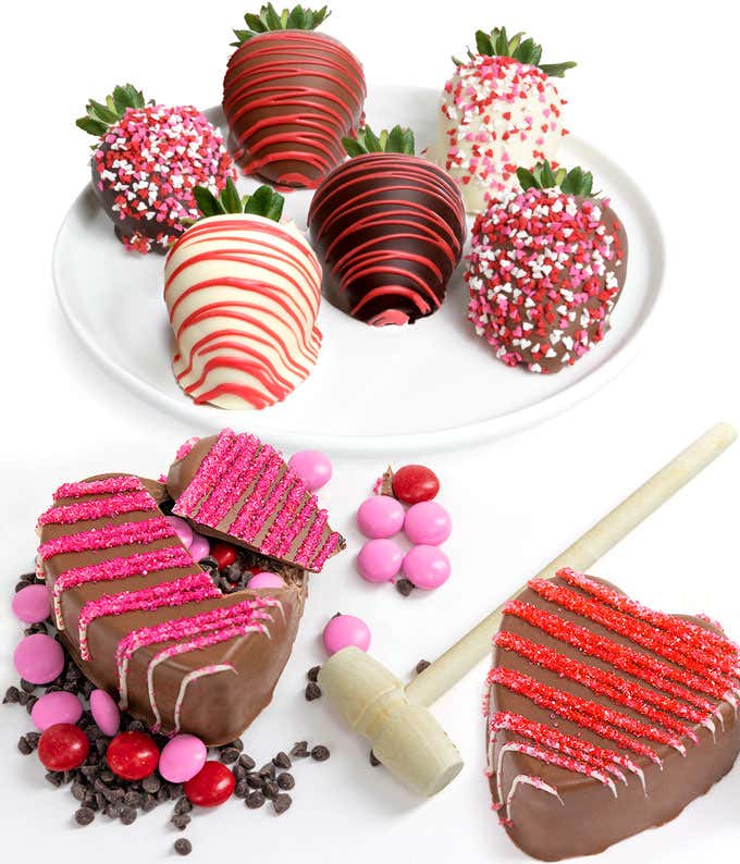 Two chocolate breakable hearts filled with M&Ms and chocolate chips, with six pink decorated chocolate covered strawberries.