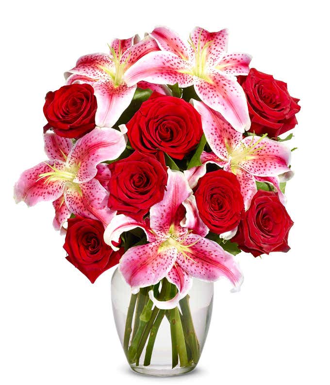 Red roses arranged with pink stargazer lilies
