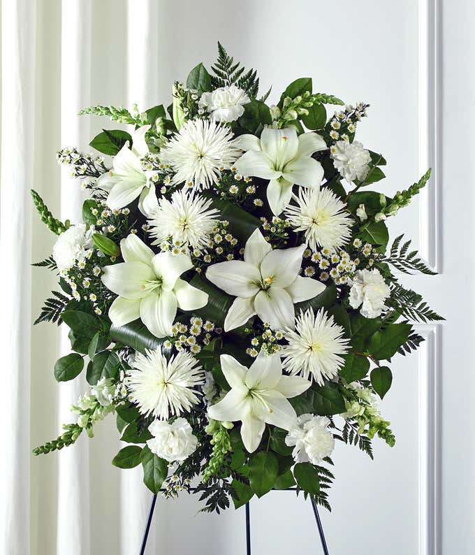 Funeral flowers with white lilies and white mums in standing spray