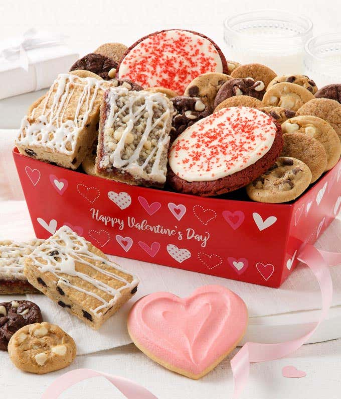 A red gift crate with hearts that says "Happy Valentine's Day" with an assortment of cookies including two frosted red velvet cookies
